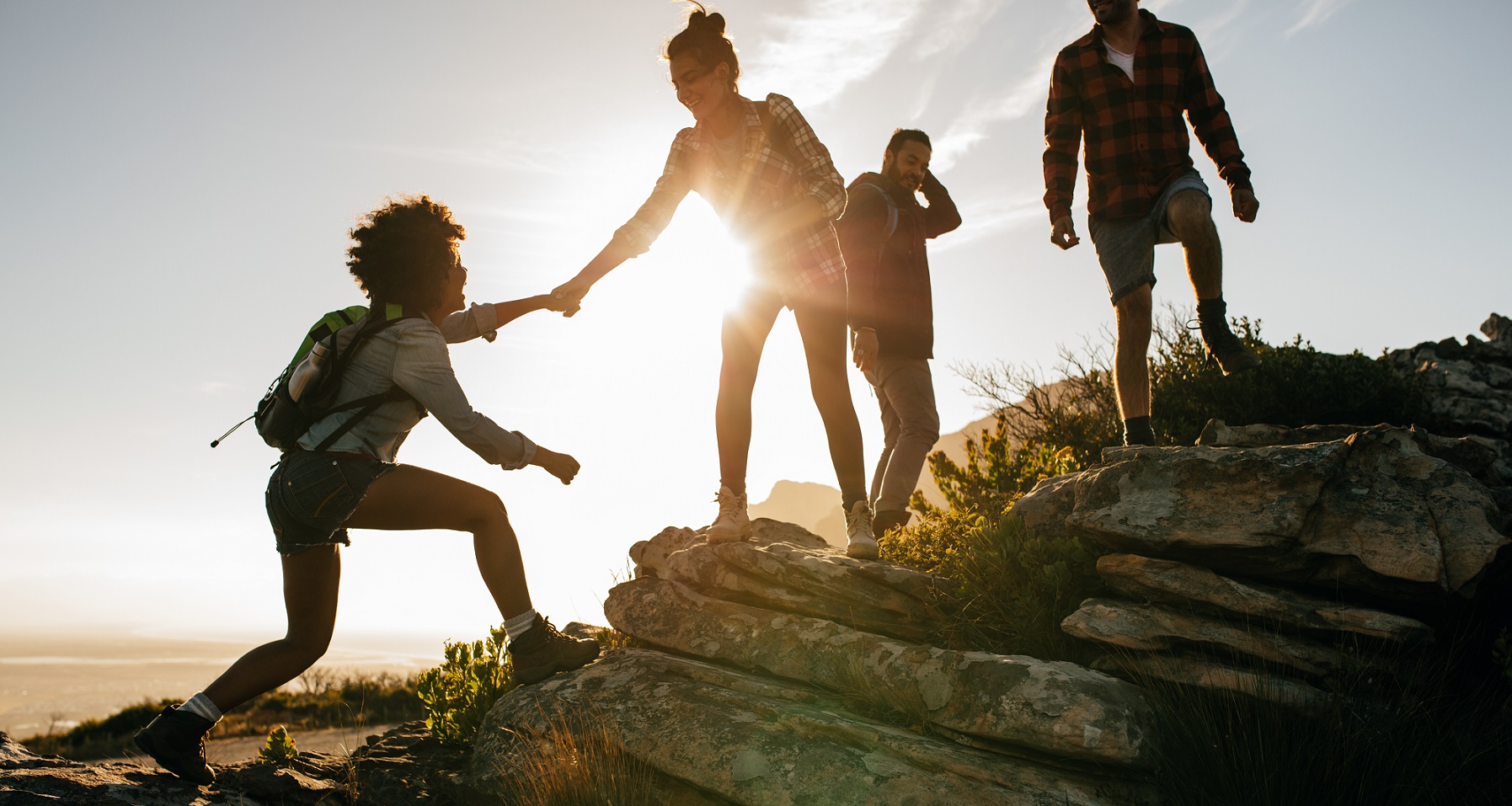 Group,Of,Hikers,On,A,Mountain.,Woman,Helping,Her,Friend