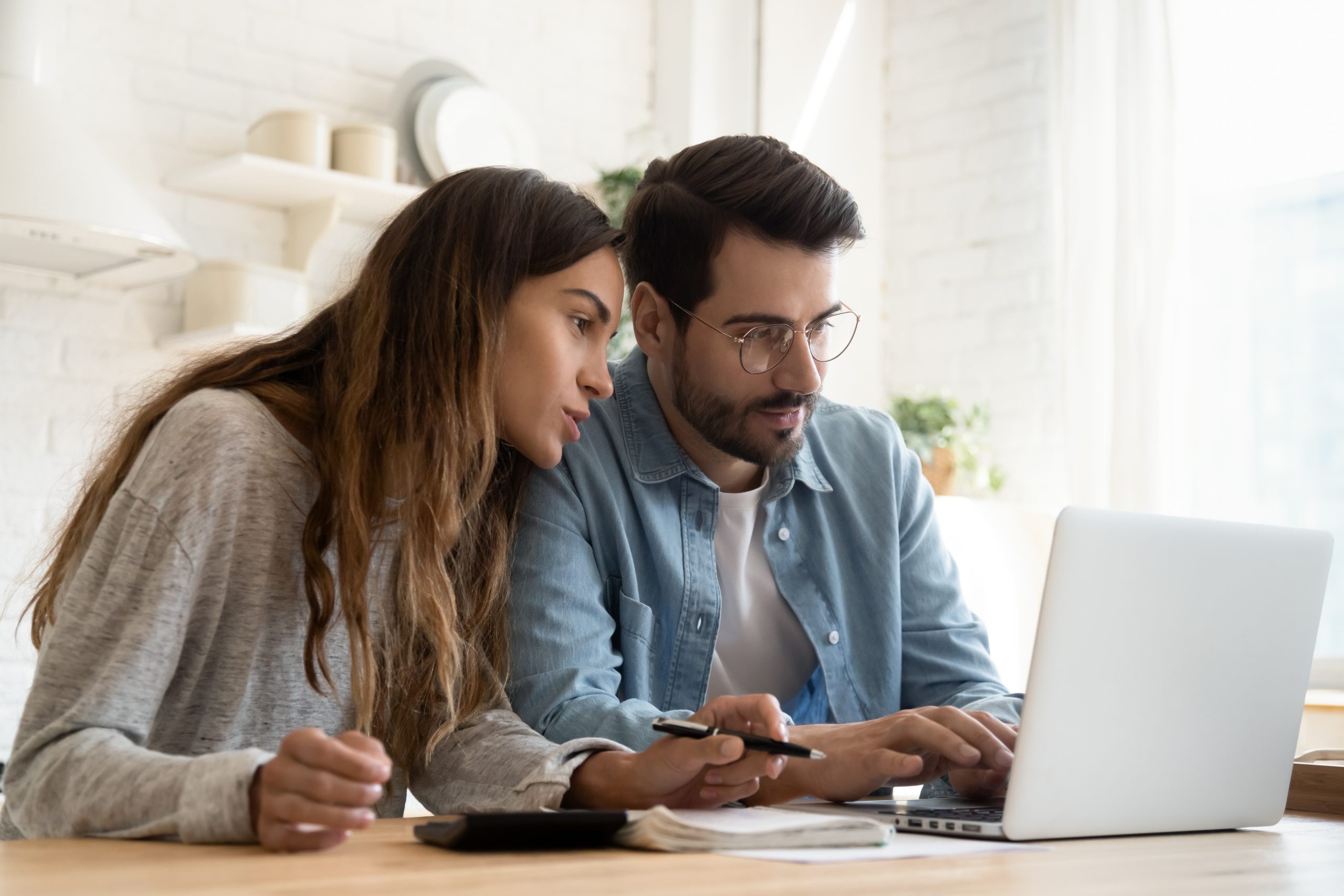 Focused,Young,Couple,Calculating,Bills,,Discussing,Planning,Budget,Together,,Serious