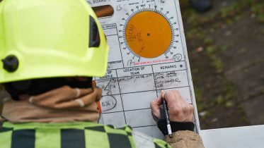 Shot over the shoulder of a firefighter updating a breathing apparatus board at an incident