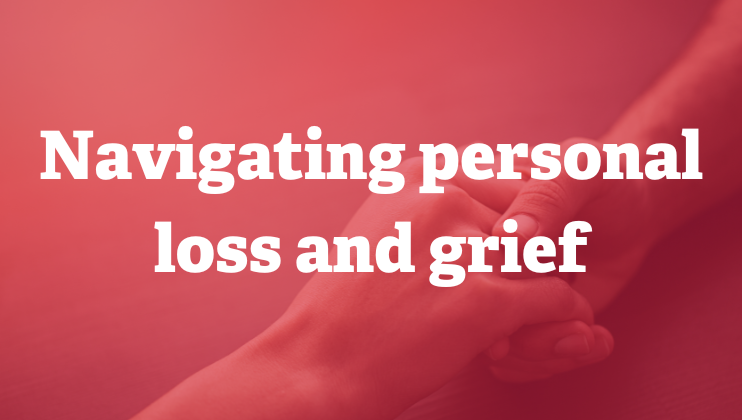 Two hands gently holding each other for comfort, overlaid with the text “Navigating personal loss and grief” on a soft red background.