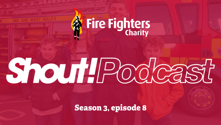 Three people stand in front of a fire engine with the words 