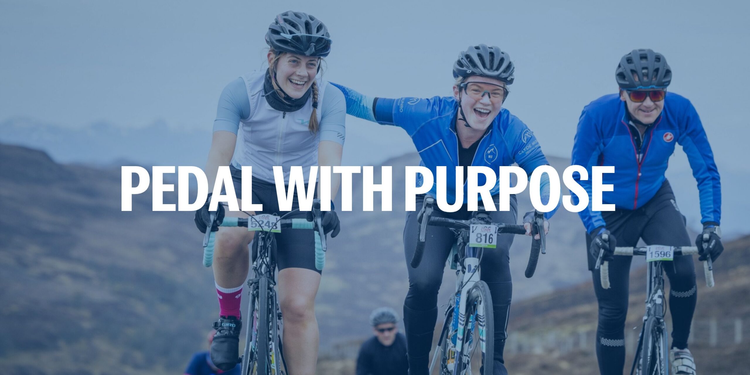 Three cyclists ride uphill, smiling and supporting each other during the Etape Loch Ness charity cycle. The text “PEDAL WITH PURPOSE” is overlaid, with mountain scenery in the background. 