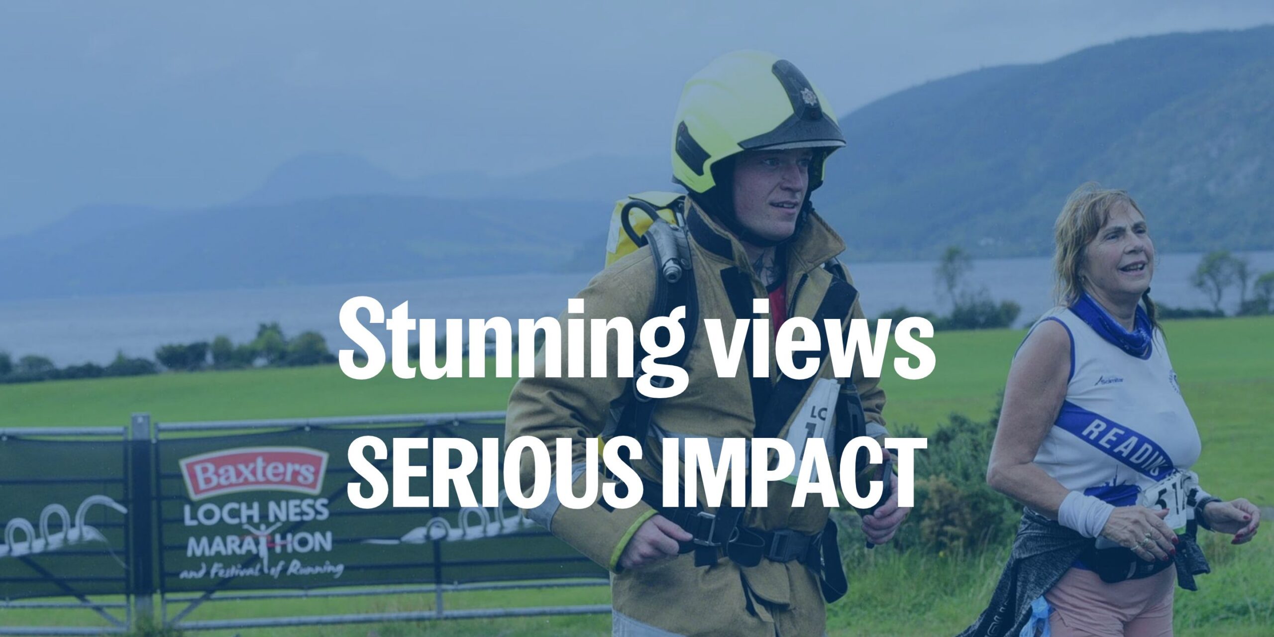 A firefighter in full gear runs alongside a woman in athletic wear during the Loch Ness Marathon. 